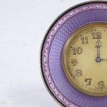 An early 20th century purple enamel and unmarked white metal-framed 8-day circular mantel clock,