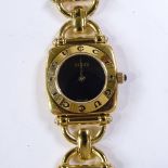 GUCCI - a lady's gold plated 6400L quartz wristwatch, circa 1997, black dial with gilt hands and