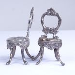 A pair of miniature silver doll's house chairs, allover relief embossed and engraved foliate