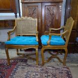 A pair of French walnut open armchairs with cane-panelled seats