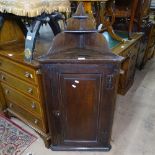 A Georgian oak hanging corner cupboard with panelled door