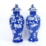 A pair of Chinese blue and white porcelain prunus pattern baluster vases and covers, 4 character