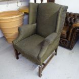A late 19th century upholstered wing fireside chair