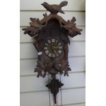 A Vintage German Black Forest cuckoo clock, bird and leaf decorated case with pine cone weights