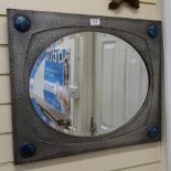 An Arts and Crafts pewter-framed oval bevel-edge wall mirror, with 4 large inset blue Ruskin
