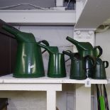 A graduated set of 5 green painted metal oil cans