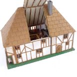 A handmade model Tudor design doll's house, complete with contents and hinged openings, height 21cm