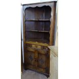 A carved and panelled oak corner cupboard with open shelves, W90cm H180cm