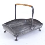 An Arts and Crafts Frank Cobb pewter basket, hand planished decoration with wicker work handle,