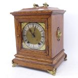 A German oak-cased 8-day bracket clock, brass dial with Roman numeral hour markers and brass lion