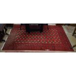 A red ground Tekki design carpet with symmetrical pattern, 300cm x 200cm