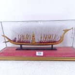 A painted and gilded model ship with oarsmen, in glazed display case, length 52cm overall
