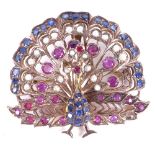 A stylised pendant/brooch, in the form of a peacock, set with sapphires, seed pearls and rubies