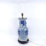 An Oriental blue and white porcelain lamp on carved wood base, height overall 70cm