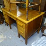 A 1930s oak kneehole writing desk, with fitted drawers