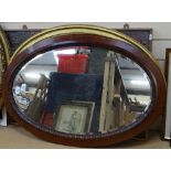 An oval inlaid mahogany framed bevelled wall mirror, 86cm