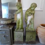 A pair of weathered concrete garden cherub figures on pedestals, overall height 170cm