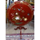 An Oriental design red lacquered tilt-top table, on tripod base, W76cm