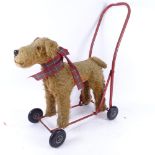 A Pedigree Soft Toys Ltd mohair child?s push-along dog, with red painted steel frame, overall length