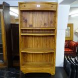 A modern hardwood bow-front open bookcase, with single drawer, W50cm