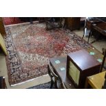 A large red ground Afghan design carpet with symmetrical pattern, 380cm x 290cm