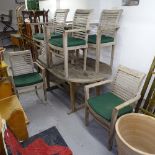 A good quality oval slatted teak extending dining table, together with a set of 8 matching armchairs