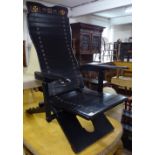 A Ghanian Susubiribi, African, ebonised reclining armchair, with chip carved painted decoration