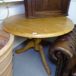 A modern circular polished pine kitchen table, on tripod base, W104cm