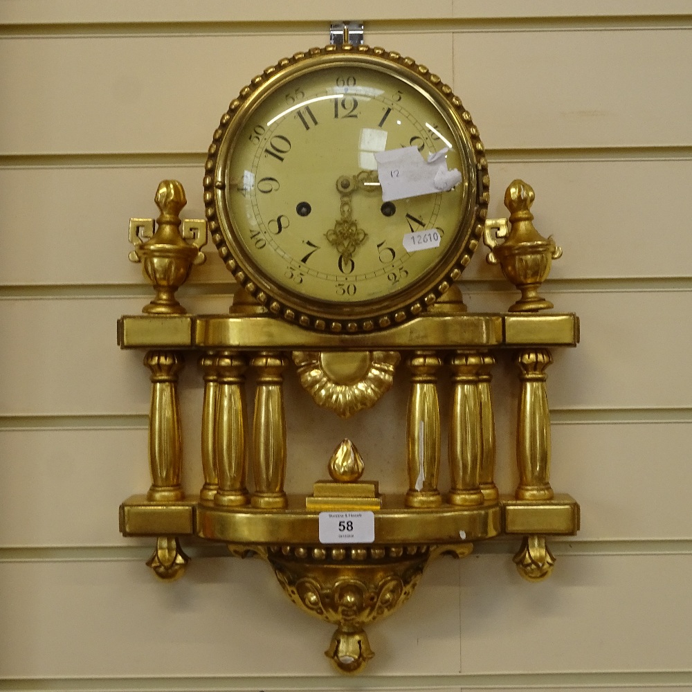 A modern German giltwood 8-day wall hanging clock, cream dial with Arabic numerals, and a pillar