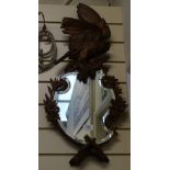A Black Forest carved wood bird of prey shaped bevel-edge wall mirror, overall height 75cm
