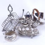 A silver plated toast rack, a 4-piece egg cup on stand with spoons, an embossed milk jug, and a 2-