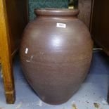 An oval glazed terracotta oil jar