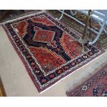 A red ground Caucasian rug, 200cm x 135cm