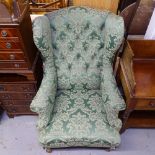 An Edwardian buttoned-back upholstered wing fireside chair