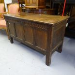 An 18th century joined oak coffer, with carved and panelled front and stile legs, W113cm