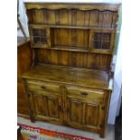 A modern oak 2-section dresser, with fitted drawers and fielded panelled cupboards, on stile legs,