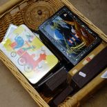 A wicker basket with boxes, tins and musical boxes