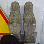 A pair of weathered concrete rampant heraldic lions