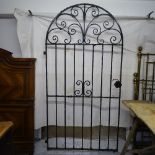 A scrolled wrought-iron arch-top garden gate, W104cm, and a scrolled wrought-iron panel