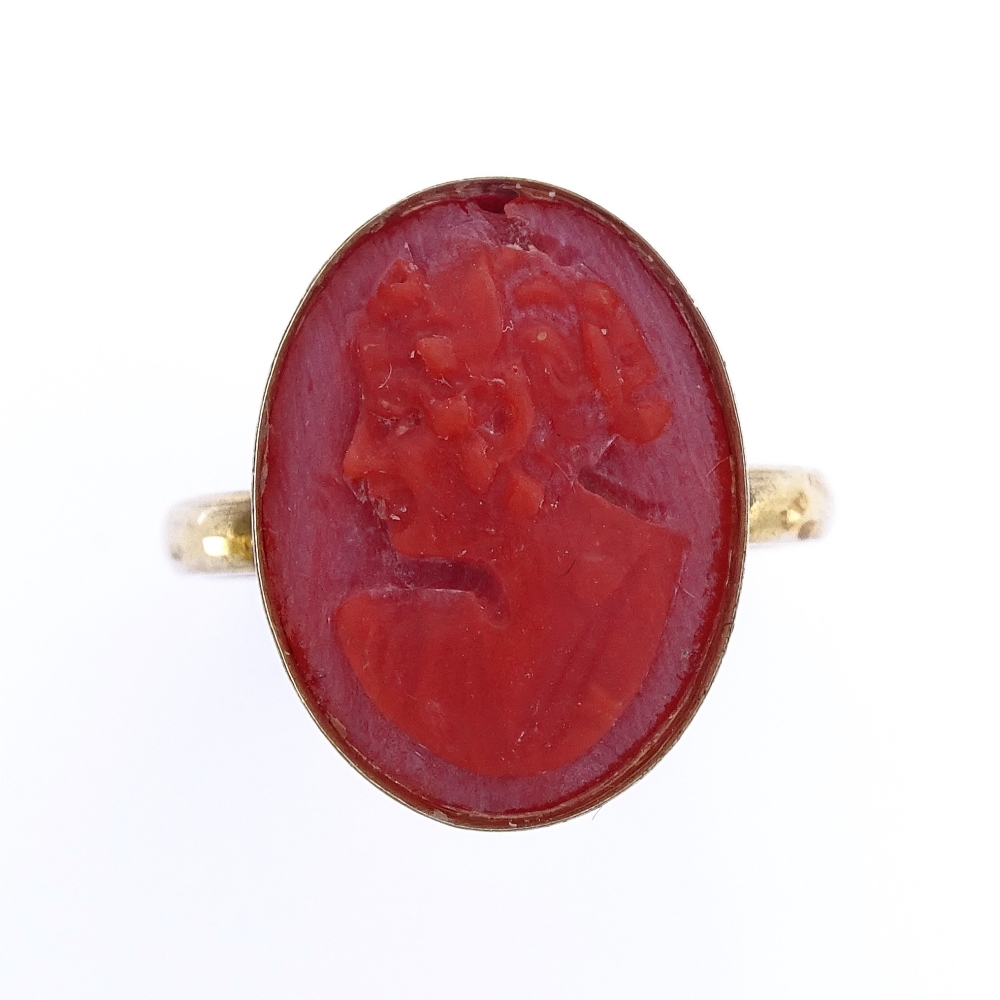 An unmarked silver-gilt relief carved coral cameo ring, setting height 16.7mm, size J, 2.5g Good