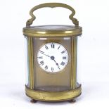 A 19th century oval brass-cased carriage clock timepiece, white enamel dial with Roman numeral