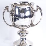 An Edwardian Irish Art Nouveau silver 3-handled trophy, planished decoration with crest and