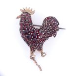 A Victorian unmarked yellow metal faceted garnet cockerel brooch, brooch height 35.8mm, 6.8g Good