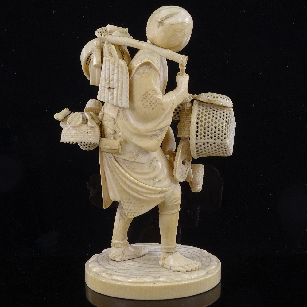 A Japanese ivory okimono of a basket seller, Meiji Period, with inset signed jade plaque under base, - Image 2 of 3