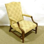 An early 19th century carved mahogany-framed open arm Gainsborough style library chair