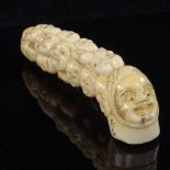 A Japanese ivory walking stick handle decorated with humorous faces, Meiji Period, signed, length