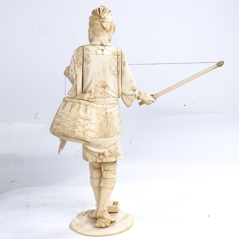 A Japanese ivory okimono depicting a fisherman with a mother-of-pearl fish, Meiji Period, height - Image 3 of 3