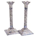 A pair of silver plated marble Corinthian column table candlesticks, relief embossed floral swag