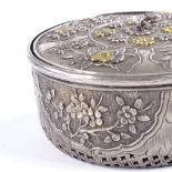 A Chinese unmarked silver cricket cage, circa 1900, parcel gilt relief decorated floral lid, and