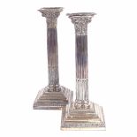 A pair of George V silver Corinthian column table candlesticks, stepped bases with removeable